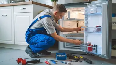 Technician inspecting the shelves and components of a compact refrigerator